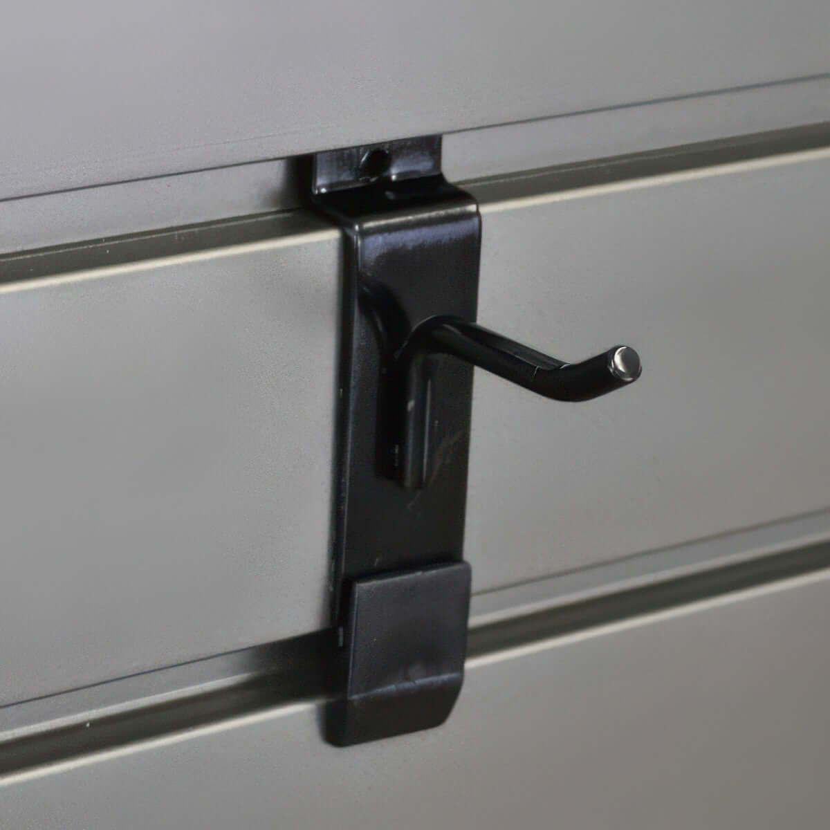 Slatwall Hooks 2-inch hook with Hook-Lok locking clip mounted securely on grey slatwall panel