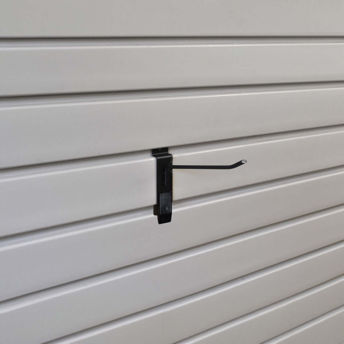 Slatwall Hooks 4" black metal hook with Hook-Lok security clip mounted on white slatwall panel