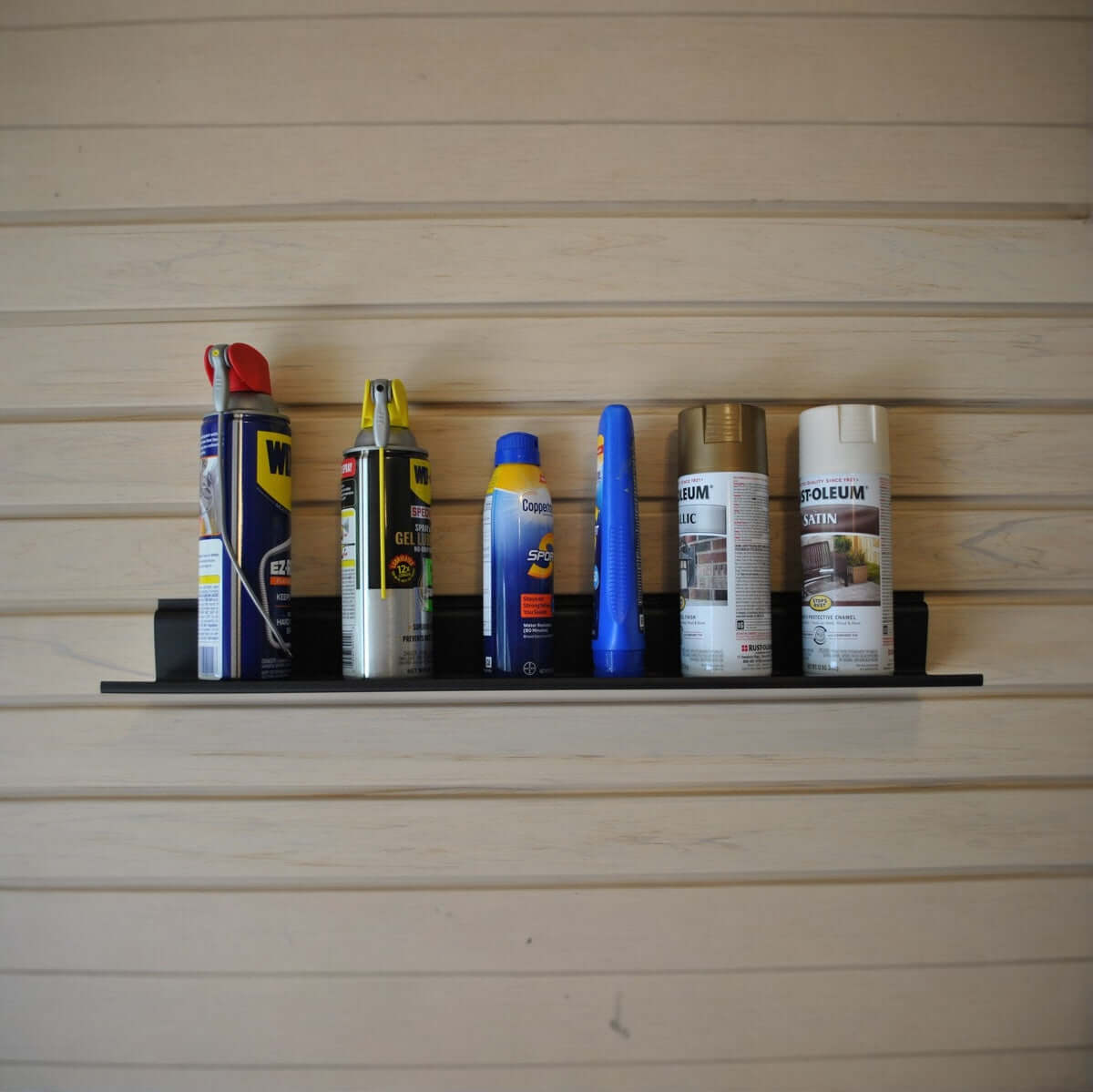 Slatwall Shelves 4" utility shelf mounted on wood panel wall holding spray cans and garage essentials