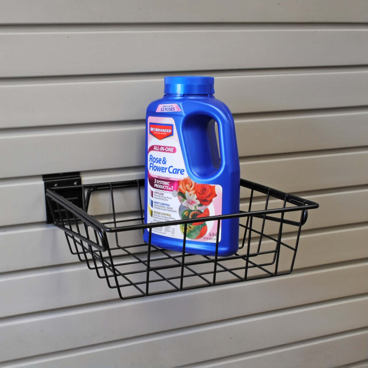 Slatwall Baskets 12x12 black wire basket mounted on garage wall holding BioAdvanced Rose & Flower Care bottle