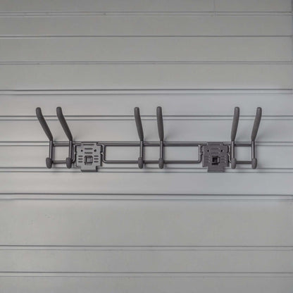 Slatwall hooks on a 24" tool bar mounted to gray slatwall panels, holding garden and garage tools organized neatly