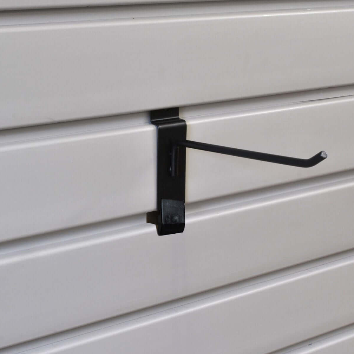 Slatwall Hooks 6-inch black peg hook with Hook-Lok locking pin mounted on white slatwall panel