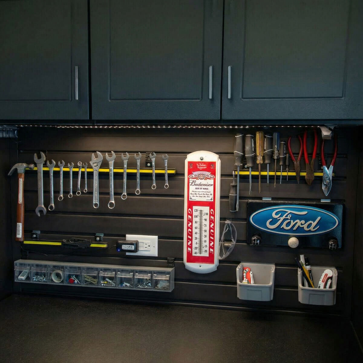 Slatwall Panels organizing a garage workshop with wrenches, screwdrivers, Ford sign, Budweiser thermometer, and small parts bins__Black