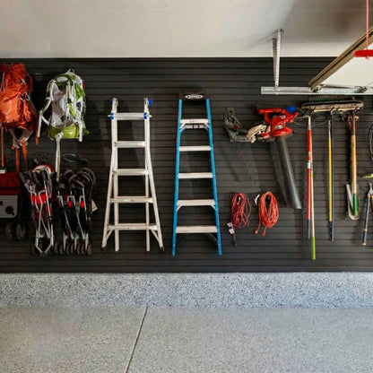 Slatwall Panels organizing a garage wall with ladders, backpacks, power tools, and garden equipment neatly displayed__Black