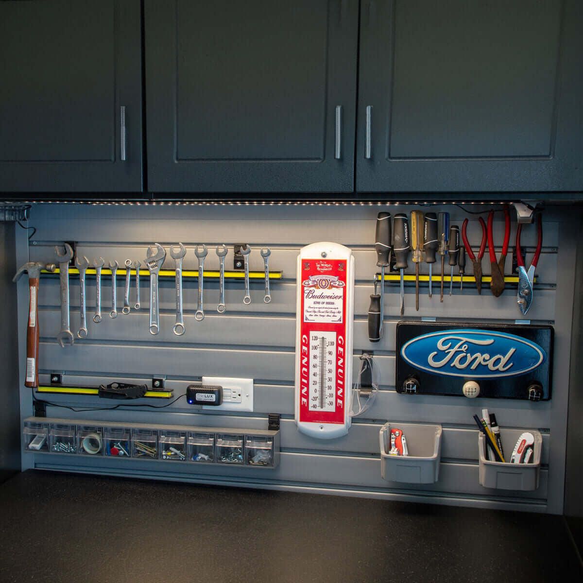 Slatwall Panels organizing a garage wall with wrenches, screwdrivers, bins, and Ford and Budweiser dacor__Gray