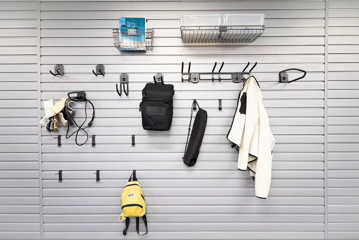 Slatwall Accessory Kits displayed on a gray wall panel holding backpacks, bags, a jacket, baskets, and various hooks