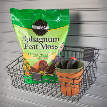 Slatwall Baskets holding Miracle-Gro peat moss, terra cotta pots, and garden tools mounted on a garage wall
