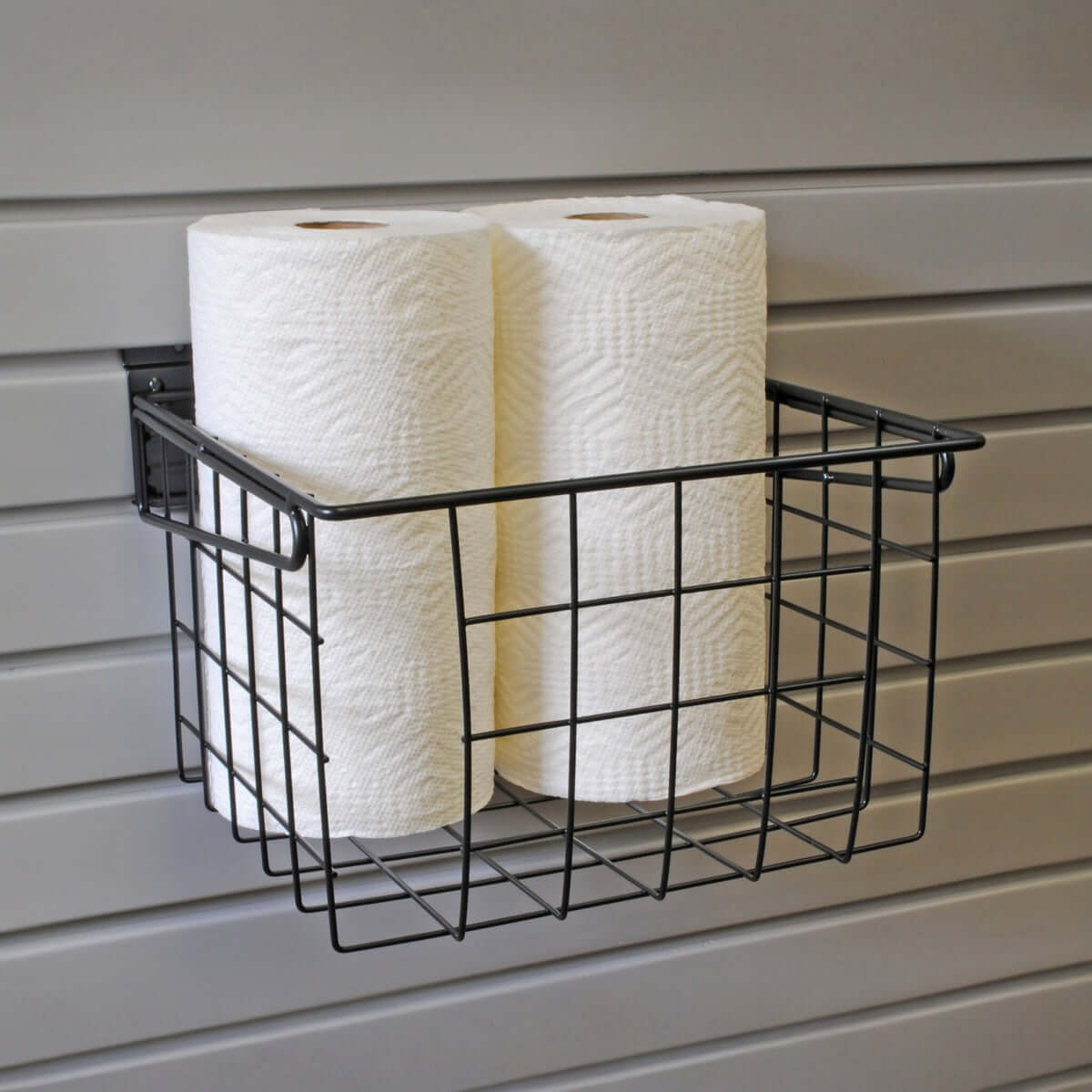 Slatwall Baskets wire organizer mounted on garage wall holding paper towel rolls, ideal for accessible storage