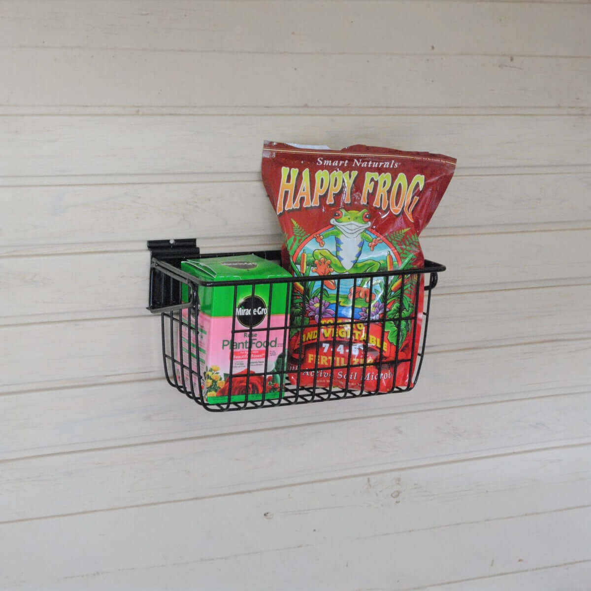 Slatwall Baskets narrow 12x6 wire basket mounted on wall holding Happy Frog fertilizer and Miracle-Gro plant food
